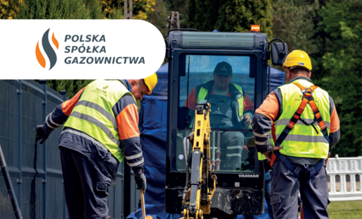 Pracownicy w kamizelkach i hełmach obsługują żółte urządzenie przy koparce, na ich stroju widoczny napis Polska Spółka Gazownictwa.